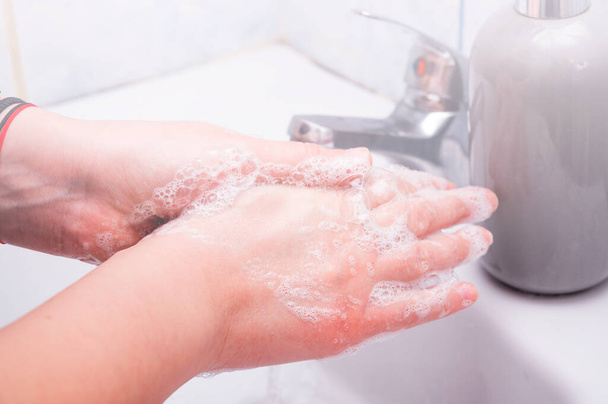 Mulher usar sabão e lavar as mãos sob a torneira de água. Higiene conceito mão detalhe - Foto, Imagem