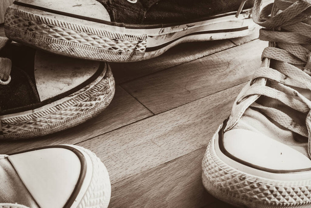 Старая обувь на фоне коричневого дерева - Фото, изображение