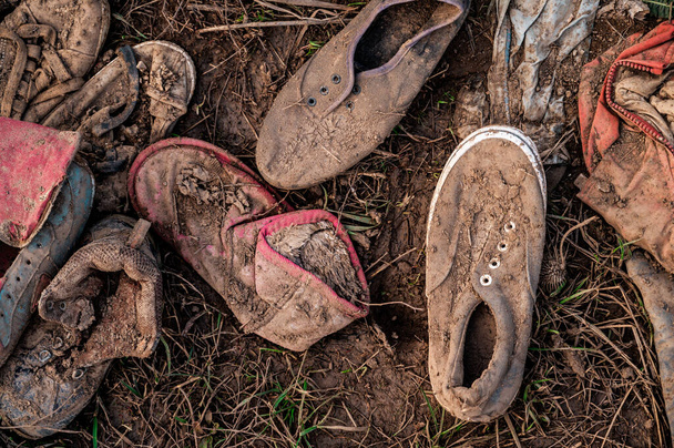 砂利の床に放棄された古いスニーカー、着用靴、ソフトフォーカス. - 写真・画像