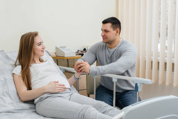 Pregnant girl in the clinic for consultation with the future father. Medical examination - Foto, immagini