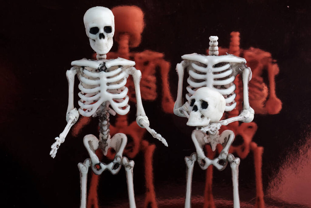 deux squelettes se tiennent debout et parlent l'un d'eux sans tête. vie après une pandémie - Photo, image