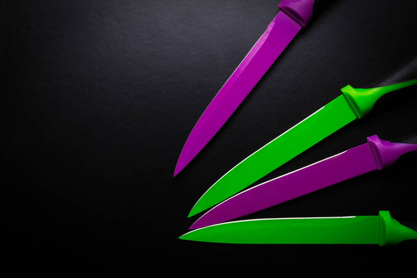 χρωματιστά μαχαίρια σε μαύρο φόντο - Φωτογραφία, εικόνα