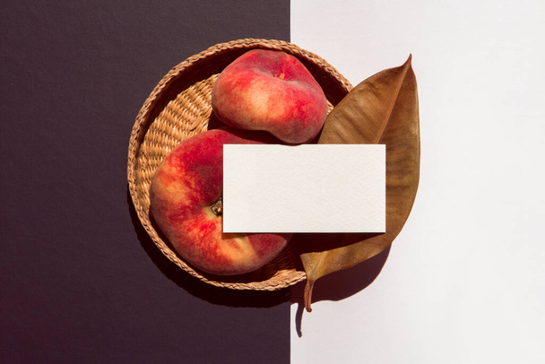 белая визитная карточка с черным фоном оставляет персики и корзину на черно-белом фоне - Фото, изображение