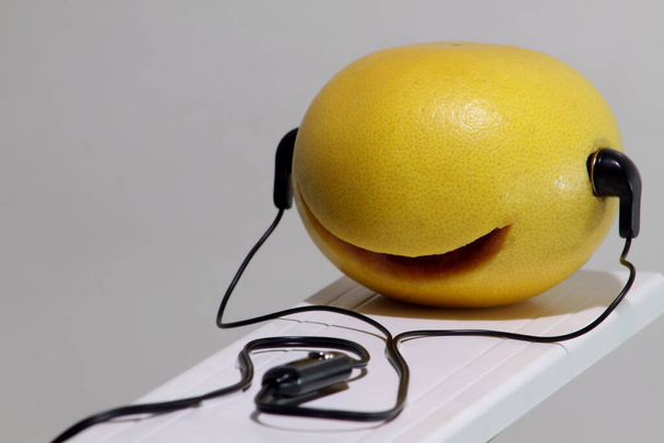Αστεία πορτοκαλί με ακουστικά  - Φωτογραφία, εικόνα