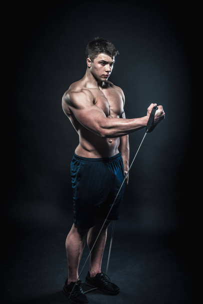Sexy young athlete posing on a black background in the Studio. Fitness, bodybuilding - Foto, Imagem