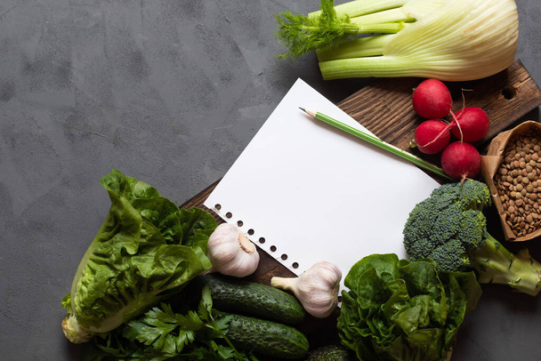 Einkaufsliste, Ernährung, Ernährung, Wochenmenü, Lebensmitteleinkauf. Gemüse liegt neben einem weißen Blatt Papier. Platz für Text. Gesunde Ernährung - Foto, Bild