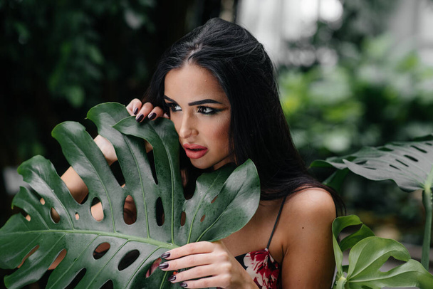 A young beautiful brunette posing among dense thickets of jungle and rainforest. Spa - Foto, Imagen