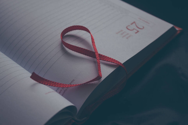 Bedrijfsconcept met papieren agenda open op 25 december en rode bladwijzer. Kerstplanning - Foto, afbeelding