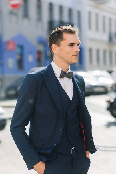 Portrait of an attractive young businessman in urban background wearing suit a necktie. - Foto, imagen