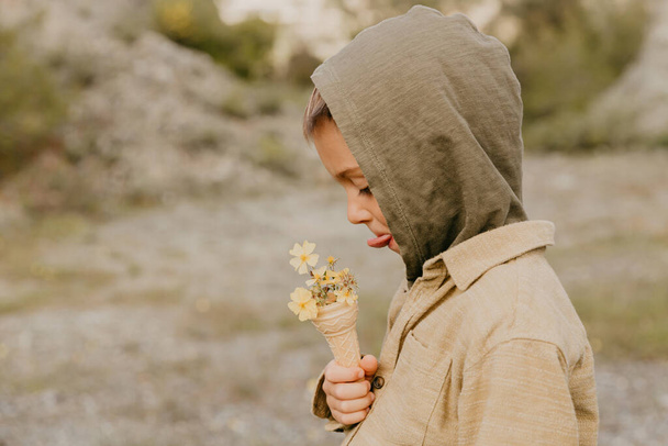 boy eating ice cream with flowers in the forest - Photo, image