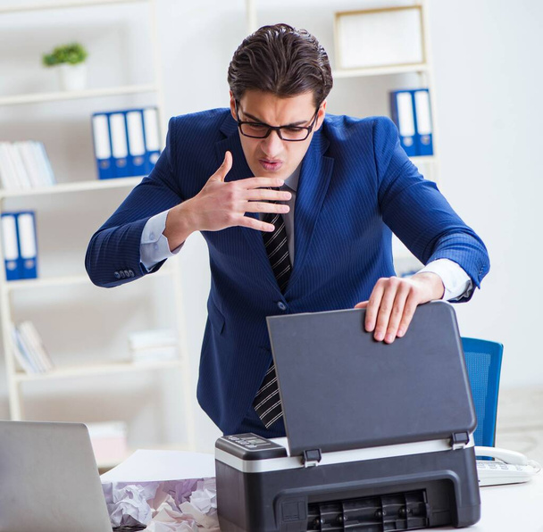 Businessman angry at copying machine jamming papers - Valokuva, kuva