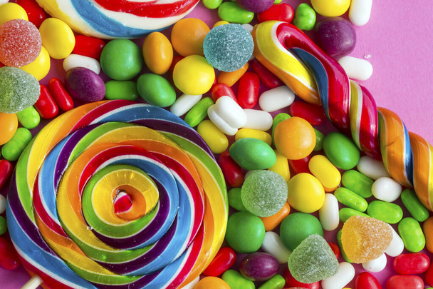 Színes nyalókák és különböző színű kerek cukorka. Felülnézet. - Fotó, kép