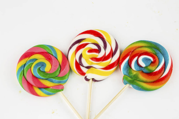 Sucettes colorées et bonbons ronds de différentes couleurs. Vue du dessus. - Photo, image