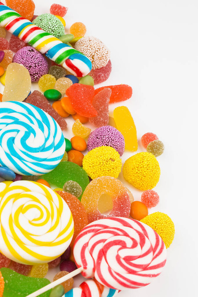 Colorful lollipops and different colored round candy. Top view. - Foto, afbeelding