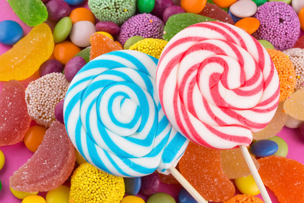 Красочные леденцы и разноцветные круглые конфеты. Вид сверху. - Фото, изображение