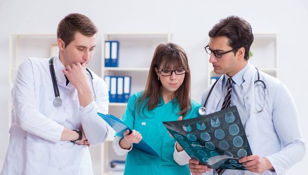 Three doctors discussing scan results of x-ray image - Photo, Image