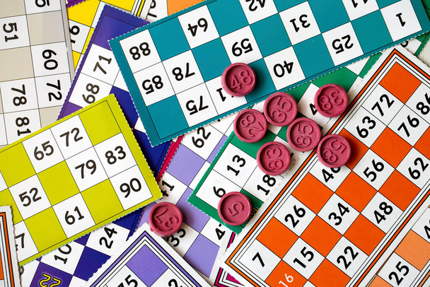 Colorful bingo game cards and numbers on white background, close up, isolated. - Foto, Imagem