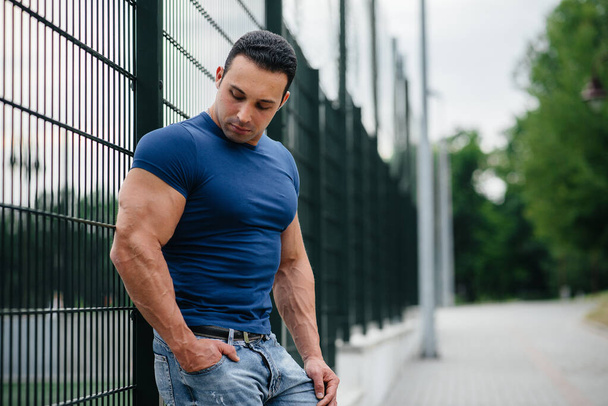 Sports guy stands near the sports field. Bodybuilding - Photo, image