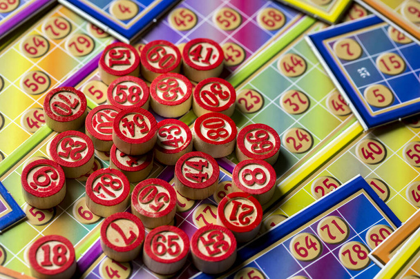 Kleurrijke bingo speelkaarten en nummers op witte achtergrond, close-up, geïsoleerd. - Foto, afbeelding
