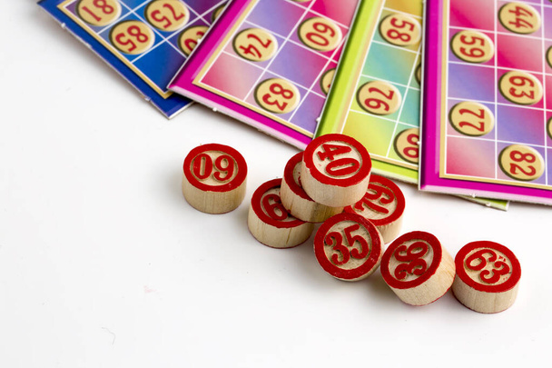 Színes bingó játék kártyák és számok fehér háttér, közelről, elszigetelt. - Fotó, kép