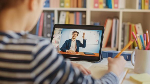 Smart Little Boy Uses Digital Tablet for Video Call with His Teacher. Screen Shows Online Lecture with Teacher Explaining Subject from a Classroom. E-Education Distance Learning, Homeschooling - Photo, Image