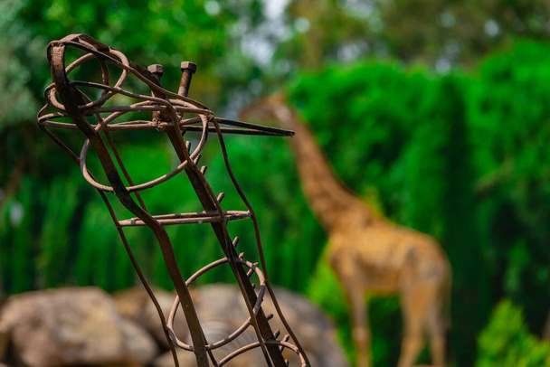 De giraffe matel standbeeld achter wazig achtergrond. - Foto, afbeelding