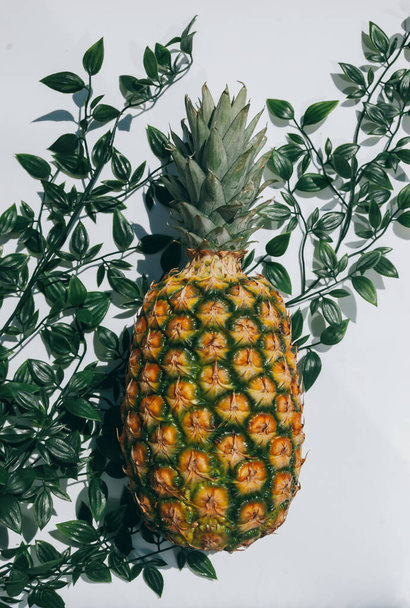 ripe juicy tropical pineapple on a yellow-white background. Space for text. Pineapple on a wooden table - Fotó, kép