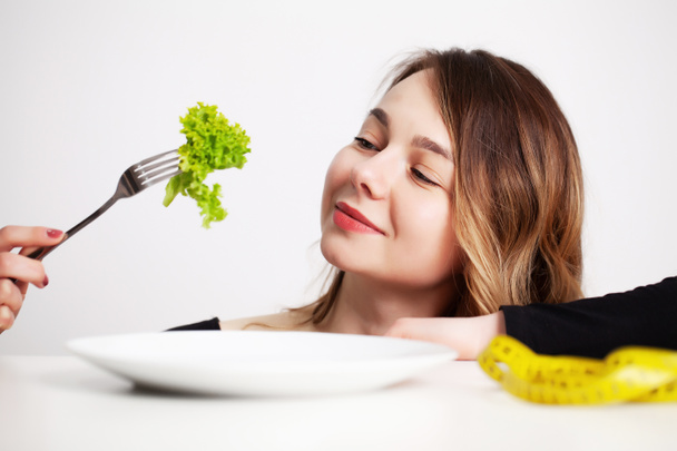 La mujer joven a la ración, come solamente la ensalada y trata de adelgazar - Foto, Imagen