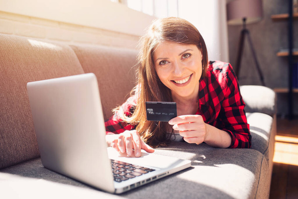 A lány kész hitelkártyával fizetni egy online áruházban. - Fotó, kép