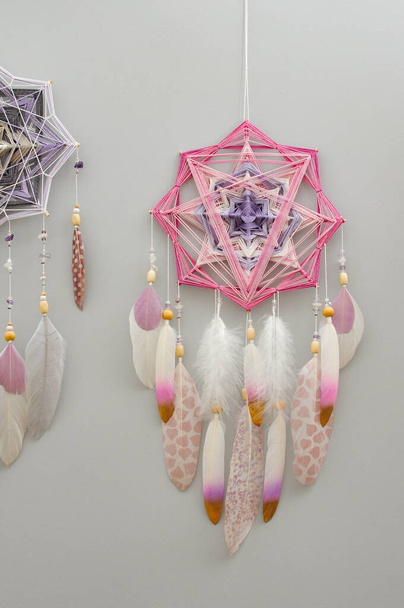Handmade woven mandala dream catcher with feathers and amethyst beads on grey background - Photo, Image