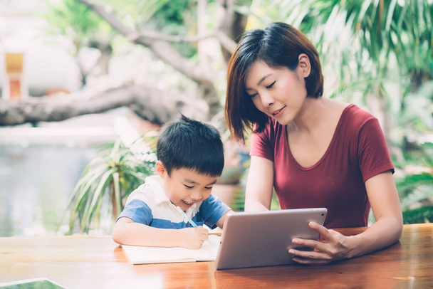 Fiam segítségével digitális tablet számítógép tanulni, és megtanulják, hogy az interneten az anyával együtt, oktatás otthonról, családi kikapcsolódás, anya tanítani fiú és házi feladatot a technológia, életmód koncepció. - Fotó, kép