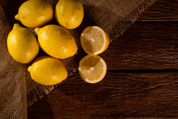 Yellow lemons on wooden background. - Valokuva, kuva
