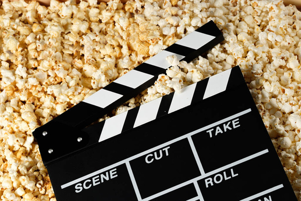 Clapper board with popcorn. Movie concept. Popcorn cracker on the background. Close-up. - Zdjęcie, obraz
