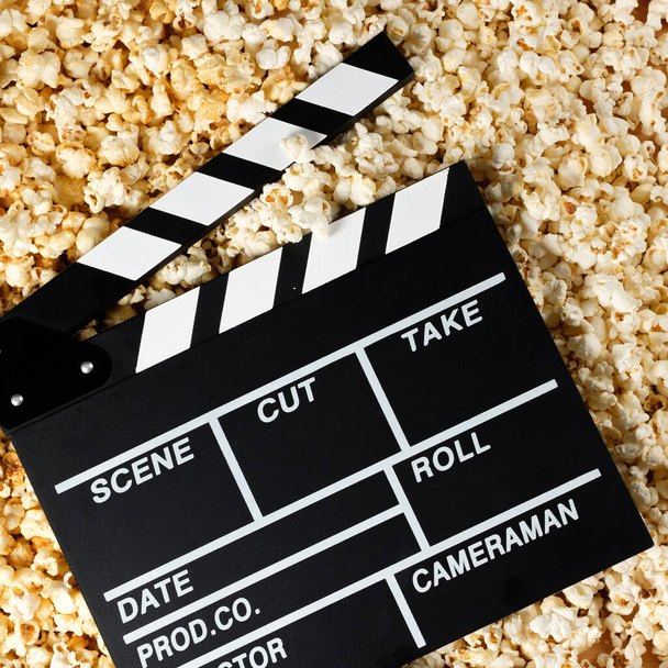 Clapper board with popcorn. Movie concept. Popcorn cracker on the background. Close-up. - Fotoğraf, Görsel