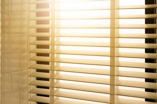 Κοντινές ανοιχτές βενετσιάνικες περσίδες. φως φάσμα ελέγχου ηλιοφάνειας που προέρχονται από ένα παράθυρο. διακόσμηση εσωτερικό. Σύγχρονη jalousie. - Φωτογραφία, εικόνα