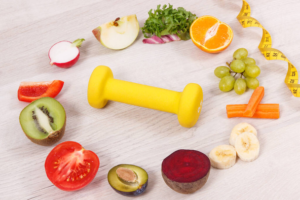 Dumbbell, tape measure and fresh nutritious food as source natural vitamins, concept of healthy nutrition and slimming - Photo, Image