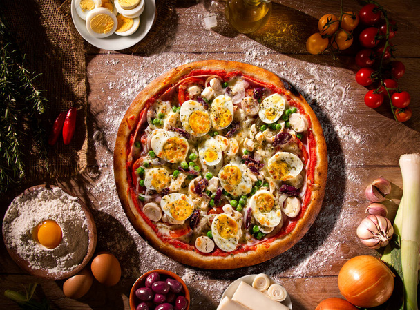 Traditional Portuguese Pizza with egg, olive, palm heart and pea. Top view on wood background, close up. Traditional Brazilian Pizza. - Fotó, kép