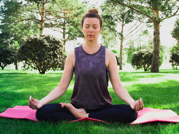 A meditáció közelsége a parkban. Sport, fitness és zen jóga koncepció.  - Fotó, kép