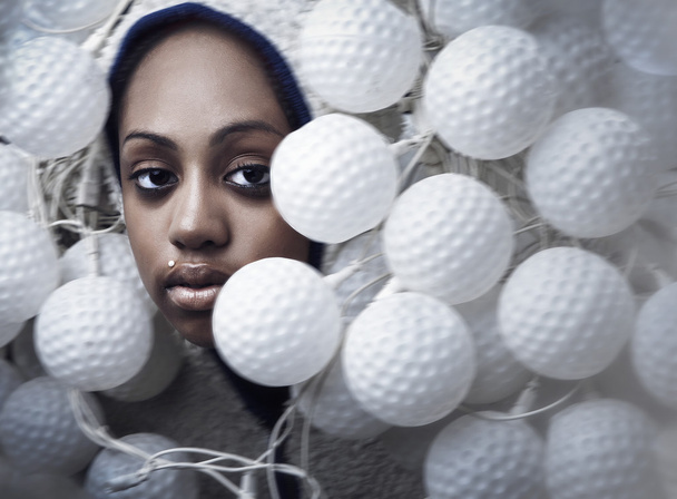 Portrait of African woman covered with fixtures in form of ball for a golf - Фото, изображение