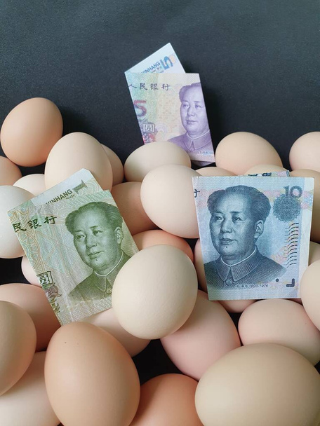 prezzo di consumo e costo di produzione di uova, banconote cinesi e cumulo di uova di pollo biologiche - Foto, immagini