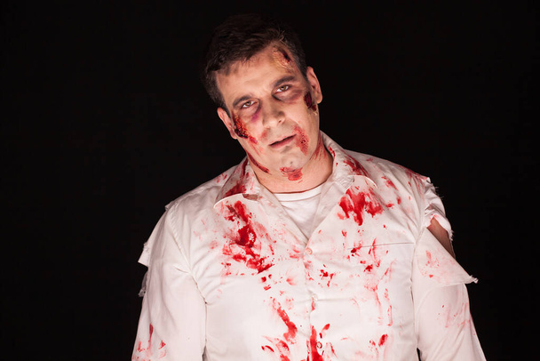 Scary and bloody zombie over black background - Photo, Image