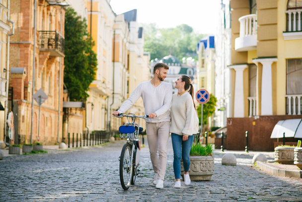 Man with bicycle and woman walking looking at each other - Photo, Image