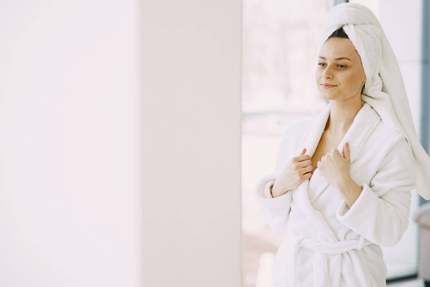 Beautiful girl in a white bathrobe at home - Fotoğraf, Görsel