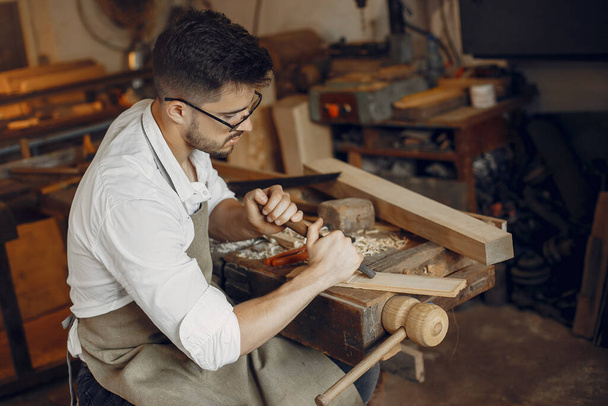 Handsome carpenter working with a wood - Zdjęcie, obraz