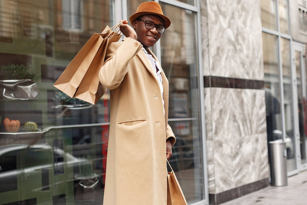 Stylish black man in a city with shopping bags - Foto, Bild
