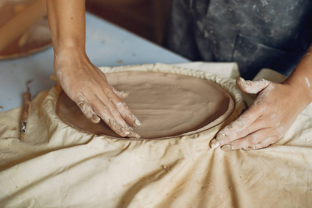 A young woman makes dishes in a pottery - Foto, Imagen