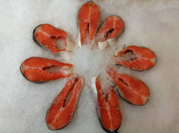 冷やした鮭のステーキは店のカウンターの上に氷の中にある。シーフードスーパーでの赤魚の肉。健康的な食事のコンセプト. - 写真・画像