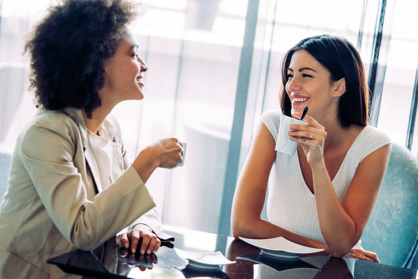 Successful happy women friends chatting in cafe during coffee break - Photo, Image