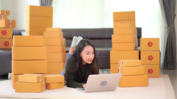 felvétel gyönyörű ázsiai nő dolgozik otthon csomagok dobozokban - Felvétel, videó