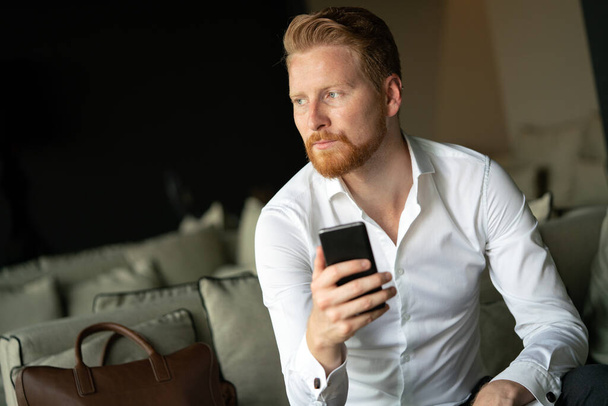 Portrait of handsome young businessman on a phone in the office - Valokuva, kuva